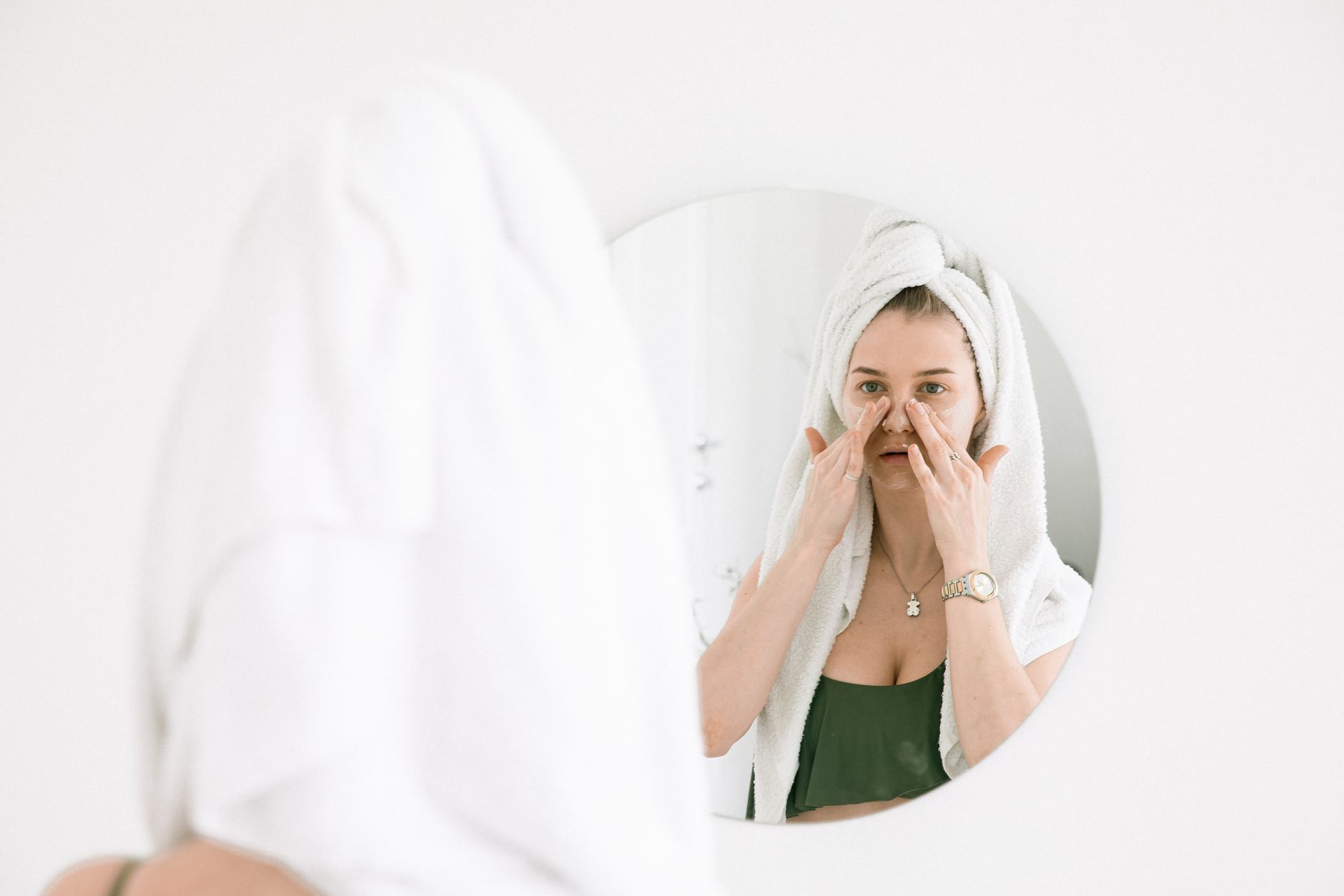 Femme appliquant sa routine de soins visage à domicile pour entretenir les résultats d'un soin en institut
