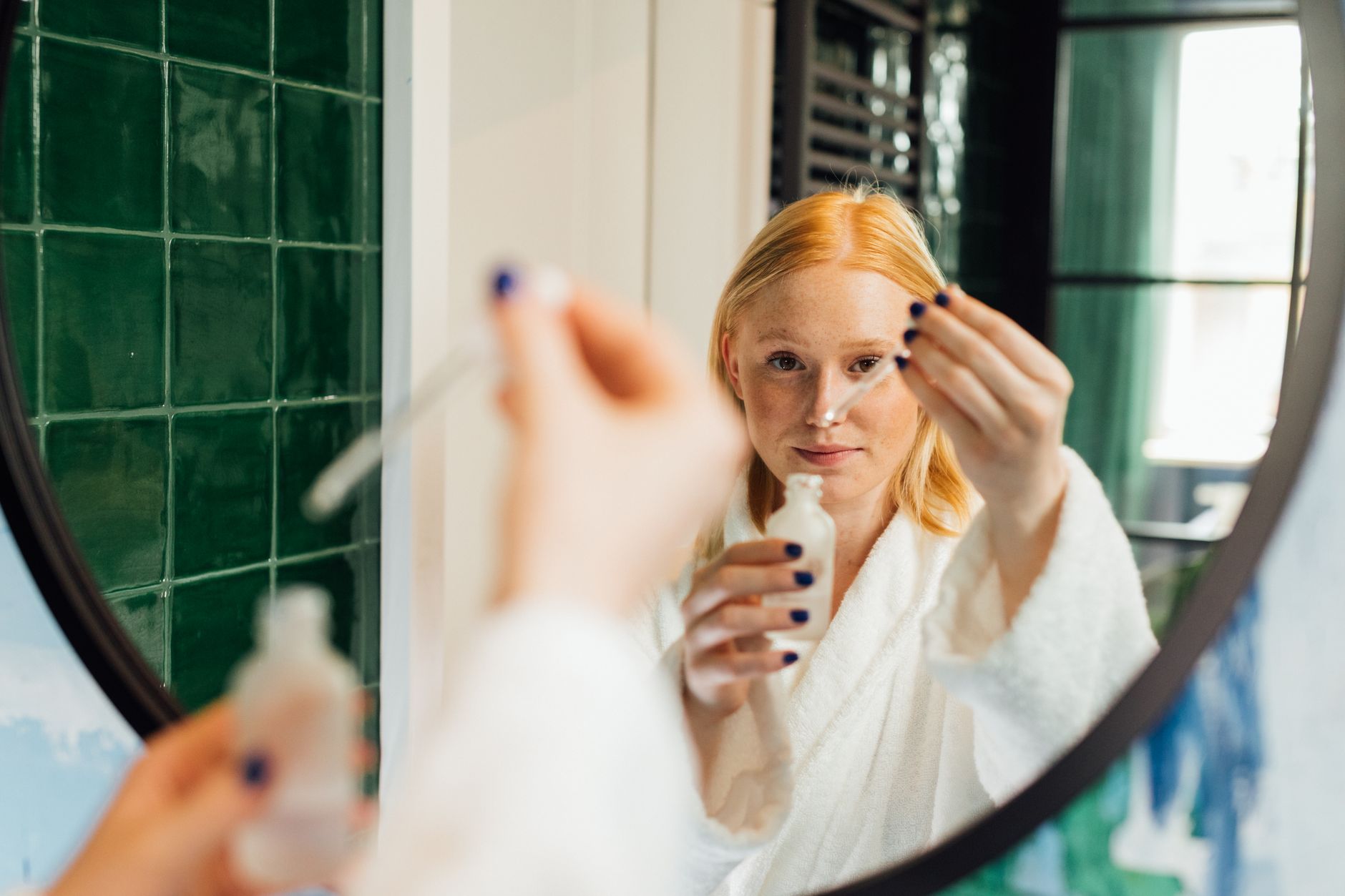 Femme appliquant son sérum dans le cadre d'une routine de soin visage à domicile à Montréal